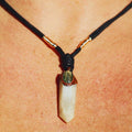 Labradorite and White Quartz Pendant Lying on Natural Stone for Cleansing