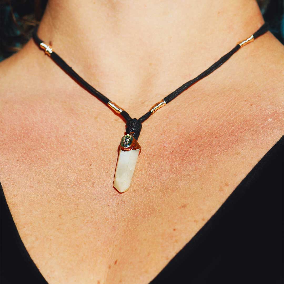 Shimmering Labradorite and White Quartz Crystal Pendant against a Soft Background